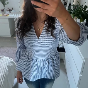 Blå- och vitrandig blus - Säljer en superfin blå- och vitrandig blus med v-ringning och trekvartsärmar. Storlek M men passar också S. Perfekt för både vardag och fest!