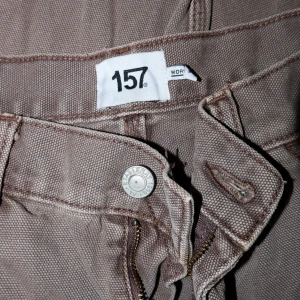 Bruna workpants  - Säljer ett par bruna workpants från Lager 157 i bra skick. Byxorna har flera praktiska fickor och en dragkedja framtill. Perfekta för en avslappnad stil och passar bra till höst och vår. De är tillverkade i ett slitstarkt material som känns bekvämt hela dagen.