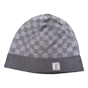 Grå rutig mössa från Louis Vuitton - Snygg grå mössa från Louis Vuitton med klassiskt rutigt mönster. Den är perfekt för kyliga dagar och har en stilren design med LV-logga framtill. Passar både till vardags och lite finare tillfällen.
