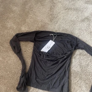 Grå långärmad topp från Gina Tricot - Säljer en supermjuk grå långärmad topp från Gina Tricot. Den har en fyrkantig halsringning och är perfekt för både vardag och fest. Toppen är i nytt skick med etikett kvar. Perfekt för höst och vår!