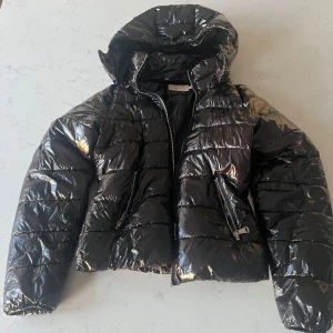 Svart glansig pufferjacka från Nelly - Nu säljer jag min svarta glansiga jacka från Nelly nu när jag har en ny, den är i storlek 36 och är i bra skick👍