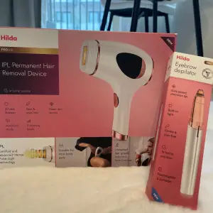 Säljer en IPL Permanent Hair Removal Device och en Eyebrow Depilator från Hilda. IPL-enheten har 5 intensitetsnivåer och en smart hudsensor för säker användning. Ögonbrynsdepilatorn är uppladdningsbar och bärbar med en guldpläterad precisionstopp för smärtfri hårborttagning. Perfekt för hemmabruk!