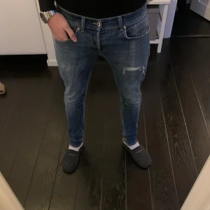 Dondup jeans - Säljer ett par snygga blå dondups i modellen George med sköna slitningar på låren. Sitter riktigt gött, och är nu marknadens hetaste jeans!! Pris ej hugget i sten 🪨 
