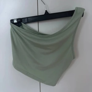 Grön oneshoulder topp - Snygg grön oneshoulder topp i mjukt material från SHEIN, endast använd en gång därav mycket bra skick!