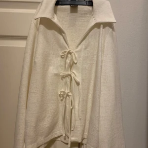 Vit långärmad skjorta med knyt - Säljer en stilren vit skjorta med långa ärmar och snygg knytning framtill. Från Gina Tricot. Använd 2 gånger. 
