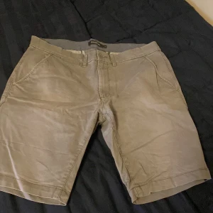 Grå shorts från Dressmann storlek M - Snygga grå shorts från Dressmann i en klassisk stil. De är typ loose fit skulle jag säga. Perfekta för sommaren! 