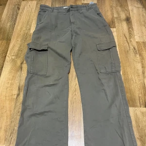 Gröna cargobyxor - Snygga gröna cargobyxor med praktiska fickor på sidorna. Perfekta för en avslappnad stil och bekväma att bära. Byxorna har en loose passform och är tillverkade i ett slitstarkt material. Priset går att diskuteras 