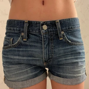 Lågmidjade Jeansshorts från AG Adriano Goldschmied - Snygga jeansshorts med upprullade kanter från AG Adriano Goldschmied. Nypris ligger på ca 1200kr-3000kr. Det är svårt att veta det exakta priset då dom slutat tillverka modellen. Shortsen är i mycket bra kvalitet och i bra skick för att vara vintage. Det går att lämna prisförslag. Skriv ifall du har några frågor.