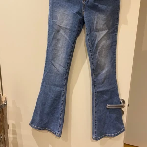 Blå bootcut jeans - Snygga blå bootcut jeans med klassisk femficksdesign. Perfekta för en avslappnad stil. De har en bekväm passform och är tillverkade i ett slitstarkt denimtyg. 
