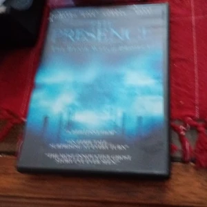 The Presence DVD - Skräckfilm på DVD med en mystisk och spöklik atmosfär. Omslaget har en blåtonad bild med dimmiga landskap och skuggiga figurer. Perfekt för en kuslig filmkväll.