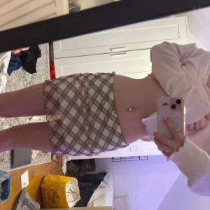 Rutig kjol från H&M Divided - Trendig kortkjol i beige och brunt rutmönster från H&M Divided. Kjolen har en tight passform och är perfekt för en stilren look. Tillverkad i polyester för en bekväm känsla.