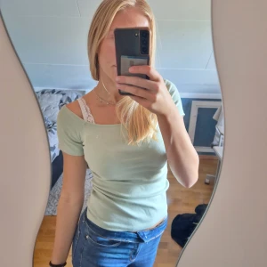 Ljusgrön topp - Snygg ljusgrön t-shirt. Ganska stor vid halsen blir lite halft off shoulder.