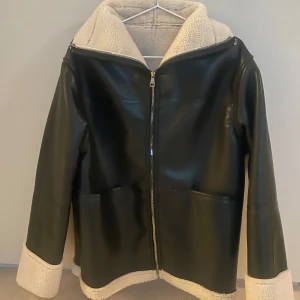 Svart syntetjacka  med foder - Svart oversized syntetjacka med mysigt vitt foder. Köpte jackan på nätet för 1500kr, passade inte och returreglerna va så stökiga så orkade inte skicka tillbaka :) Bättre nån annan drar nytta av den 🤷‍♀️ Helt ny, aldrig använd.