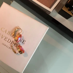 Caroline Svedbom örhängen  - Guld örhängen i färgen ”rosé Peach” från Caroline Svedbom i nyskick. Nypris är 695kr. Box ingår. 