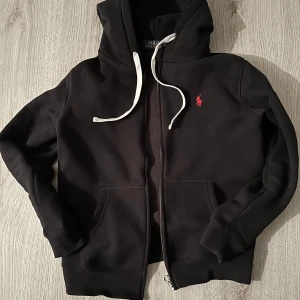 Svart hoodie från Ralph Lauren - Säljer en äldre modell av Ralph Lauren. Använd en gång sen bara legat i garderoben så den är i nyskick. M men liten i storleken