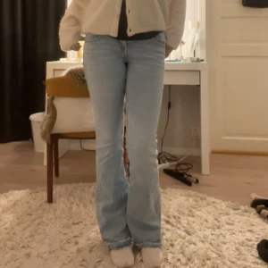 Ljusblå bootcut jeans - Jeans från Gina tricot med knappar ibak på fickorna, uppsprättade vid fötterna och passar mig som är ca 170. Väldigt sparsamt använda☺️