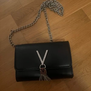 Valentino väska - Svart axelrems väska från valentino, den har ett långt band till och ett fack inuti. Knappt använd och är som ny