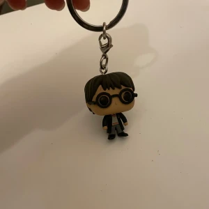Nyckelring med figur Harry Potter - Charmig Harry Potter nyckelring. Perfekt för att ge din nyckelknippa en personlig touch! Nyskick!