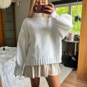 Vit stickad oversized tröja - Säljer en vit stickad tröja med en oversized passform. Tröjan har långa ärmar och ribbade detaljer vid ärmslut och nederkant. Perfekt för en mysig och stilren look. Köpte på Plick för 500 kr men den ser ut som ny, exakt som på bilden!!!