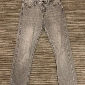 Jack and Jones jeans - Säljer ett par grå jeans från Jack and Jones  i modellen Relaxed/Chris. De har en avslappnad passform med klassisk femficksdesign och knappgylf. Perfekta för en skön komfort och stilig look.