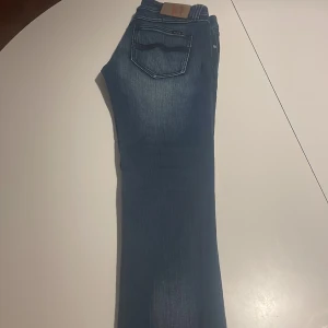 Blå jeans från Nudie - Snygga blå jeans från Nudie med klassisk femficksdesign och en diskret logga på bakfickan. Perfekta för en avslappnad stil. Skriv om ni har några frågor!🙌