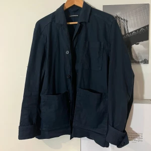 Mörkblå overshirt från J.Lindeberg - Snygg mörkblå overshirt från J.Lindeberg med knappar framtill och fickor. Perfekt för lager-på-lager-stil. Passar bra till en dag på stan eller en middag🍝✅😁