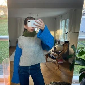 Stickad tröja med färgblock - Säljer en unik stickad tröja med coola färgblock i grått, blått och grönt. Tröjan har långa ärmar och en loose passform, perfekt för höst och vinter. Den är supermysig och stilren 💚💙🩶