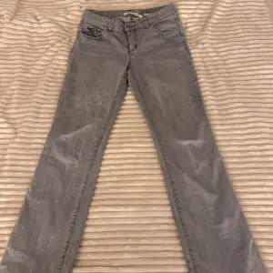 Gråa jeans i bra skick med snygga broderade detaljer på bakfickorna. Jeansen är avklippta nedtill men passar mig som är 167. Skulle säga att storleken är 36/38. Hör av dig om du har frågor!🌟