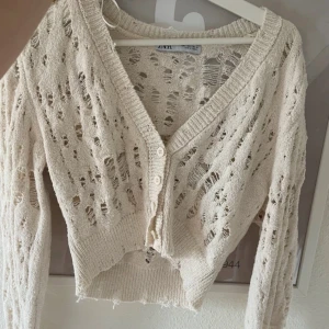 Beige stickad kofta från Zara - Säljer en superfin vit stickad kofta från Zara. Har en v-ringad design med knappar framtill. Perfekt för vår och sommar! 🧶