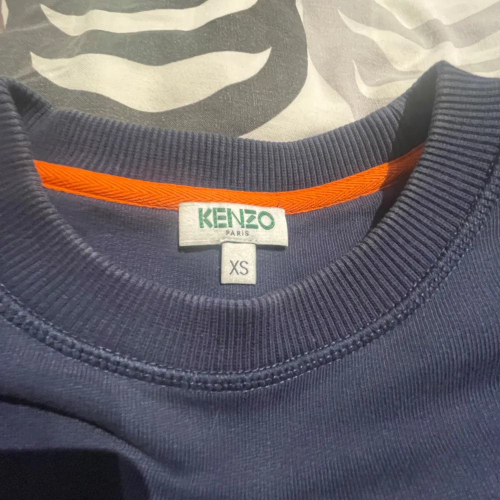 Säljer en mörkblå Kenzo sweatshirt i mycket bra skick. Den har ett coolt tigerbroderi i silver och blått med orange detaljer på framsidan. Perfekt för höst och vår! Passar både till vardags och fest. 🐯✨stor i storleken passar S och lite större . Tröjor & Koftor.