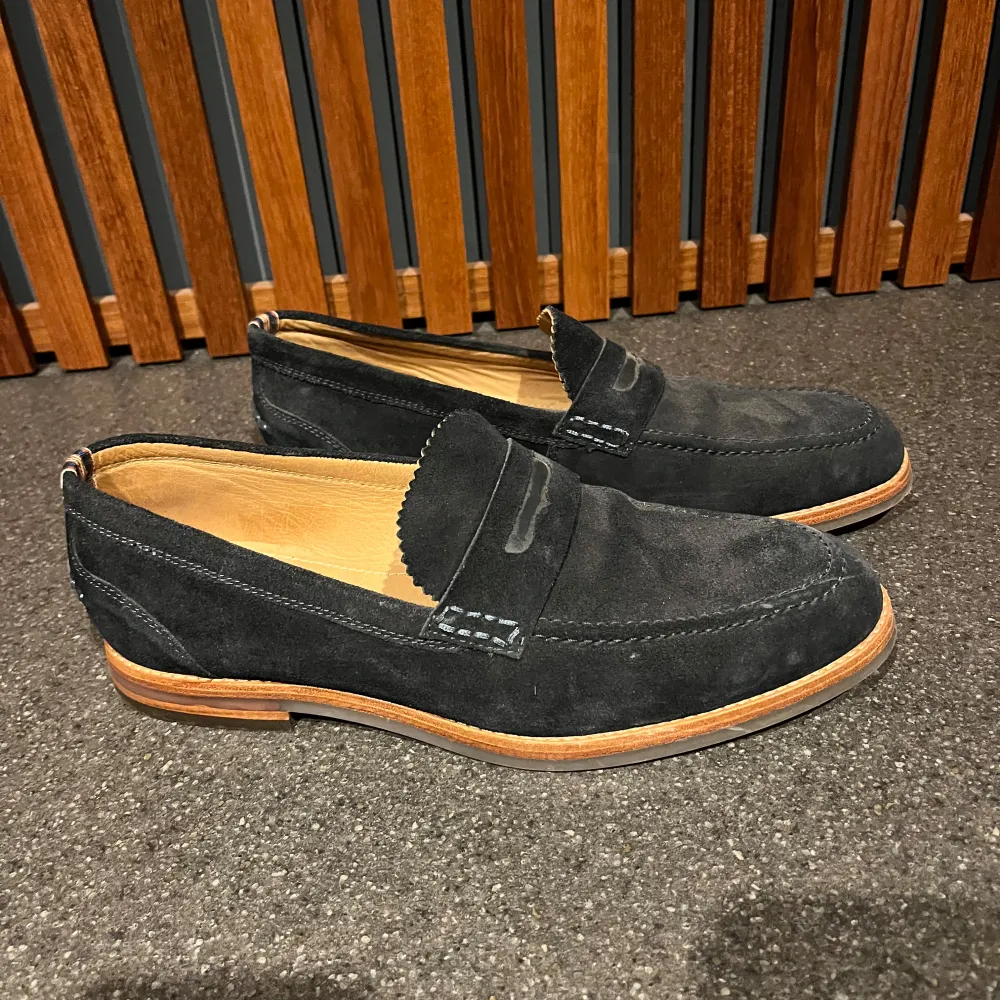 Snygga marinblå loafers i mocka från Hudson London. De har en klassisk design med en stilren söm och en bekväm innersula. Perfekta för både vardag och festliga tillfällen. Sulan är i ljust material som ger en fin kontrast till det mörka mockaskinnet.. Skor.