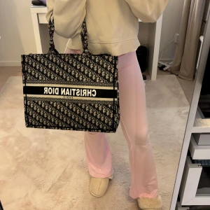 Väska - Väskan är rymlig och perfekt för shoppingturer eller som en chic vardagsväska. Den har två handtag och är i mycket bra skick. Perfekt för dig som vill ha en stilren och lyxig look! 🖤🤍 (ej äkta)