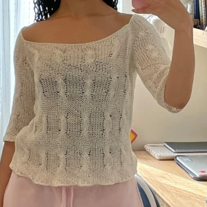 Vit stickad tröja från Status - superfin VINTAGE vit stickad tröja från Status. Den har en offshoulder-design och trekvartsärmar, perfekt för vår, höst och sommar. Tröjan är i ett luftigt stickat material som ger en avslappnad och chic look. Perfekt för både vardag och fest! 🌼