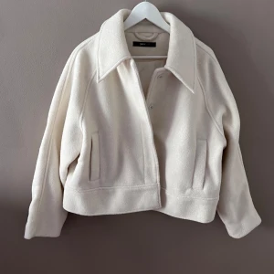 Beige jacka från Gina Tricot - Säljer en superfin beige jacka från Gina Tricot i storlek L. Den har en stilren design med knappar framtill och långa ärmar. Perfekt för höst och vår! Jackan är i nyskick och gjord av ett mjukt material som känns skönt mot huden. Passar både till vardags och lite finare tillfällen.