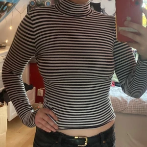 Randig polotröja - En svart och vitrandig polotröja från Monki! Knappt använd och har stretchigt material. 