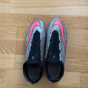 NIKE AIR ZOOM MERCURIAL SUPERFLY ELITE 9 FG XXV - SILVER/ROSA - Fick dom av min vän gratis men dom passade inte så jag tog bort snören. Storlek 44.5  Är i helt okej skick har ett litet hål där bak som knappt märks av.  Pris går att sänkas vid snabb affär.