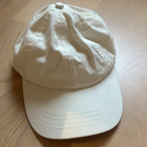 Vit beige keps - Säljer en stilren vit keps 💕 Perfekt för sommardagar eller som en enkel accessoar till din outfit. Kepsen har en justerbar rem baktill för bästa passform 💗