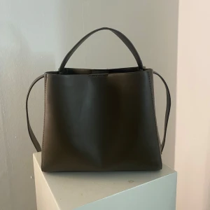 Handväska  - ”Pu midi bag” från Gina Tricot som är slutsåld. Handväska med både långt och kort band. Jätte rymlig väska och snygg. Det finns inga defekter och i jätte bra skick. 