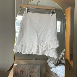 Vit kort kjol - Vit kor kjol med blommig volang