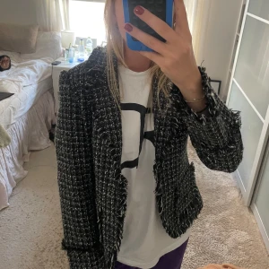 Svartvit rutig kavaj - Säljer en snygg svartvit rutig kavaj med fransiga detaljer. Perfekt för höst och vår, och funkar både till vardags och fest. Kavajen har en normal passform och långa ärmar. Den är gjord i ett bekvämt material som känns lyxigt. Köpt second hand men i bra skick! Originalt från Åhléns 