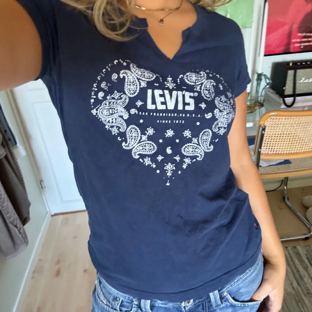 Säljer en snygg mörkblå t-shirt från Levi's med ett coolt paisleymönster i form av ett hjärta på framsidan. T-shirten är kortärmad och har en normal passform💙. T-shirts.