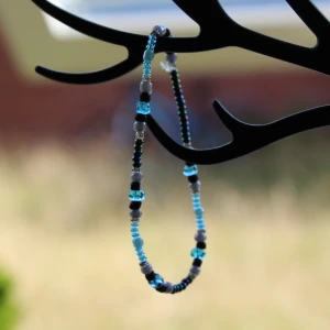 Färgglatt pärlarmband - Säljer ett superfint armband med pärlor i olika färger som blått, svart och grått. Perfekt för att ge lite färg till din outfit! Armbandet är elastiskt och passar de flesta handleder. Perfekt för både vardag och fest!