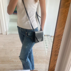 Svart axelväska från BikBok - Säljer en svart axelväska från BikBok. Väskan har en snygg triangulär detalj på locket.💕