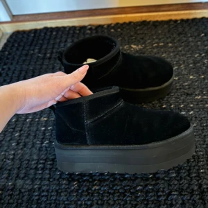 Ugg mini platform - Säljer nu mina älskade UGG mini platform i svart mocka. Storlek 38-38,5. Inköpta vintern 2024 så endast använda en halv säsong. Säljer då jag behöver plats för annat tyvärr. Impregnerade och fina i sitt skick!
