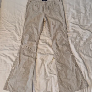 Lågmidjade beige cargobyxor - Lågmidjade beigea cargobyxor i skönt material från SO... GSjC som inte säljs längre. I bra nyskick utan fläckar och hål. Köpt här på plick men passar inte så jag säljer vidare de. Storlek 76 i midja och 80 i innerben.