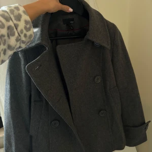 Jättesnygg kappa - Jättefin till hösten! Bra skick, från Hm men köpt här på plick. Mörkgrå i färgen med fin detalj i ryggen🙌🏻