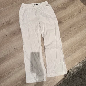 Vita linnebyxor med ficka  - Säljer ett par vita linnebyxor med en ficka där bak och en ribbad midja. Storlek S. (Köparen står för fraktenk) 
