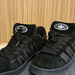 Adidas campus 00 -  Skorna har en bekväm passform och är tillverkade i mocka med snörning framtill. Perfekta för en stilren look.