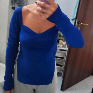 Blå ribbad topp från SHEIN - Snygg blå ribbad topp från SHEIN med långärmad design och en smickrande v-ringad hals. Perfekt för att lägga till en pop av färg i din garderob. Passar bra till både jeans och kjol.