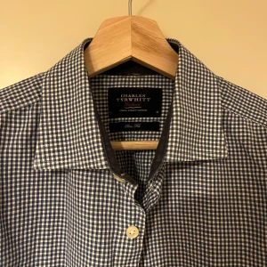 Rutig skjorta från Charles Tyrwhitt - Snygg rutig skjorta från Charles Tyrwhitt i blått och vitt. Skjortan har långa ärmar och klassisk krage med knappar framtill. Perfekt för en stilren look.